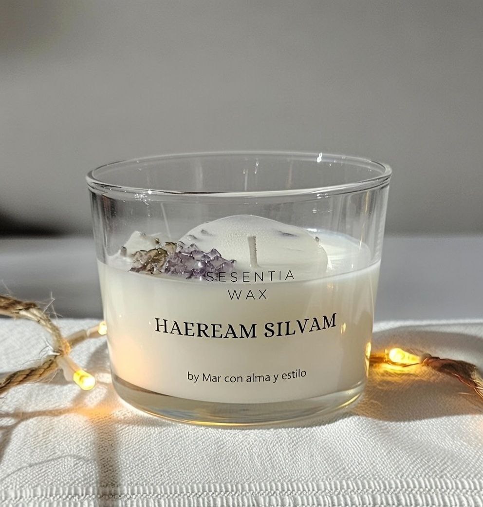 Vela artesanal de cera de soja y coco con aroma a bosque, en vaso de cristal, decorada con hojas y flor de cedro.